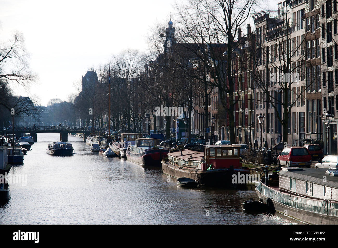 Canal nel quartiere Jordaan con case galleggianti e canal tour in barca in inverno. Foto Stock
