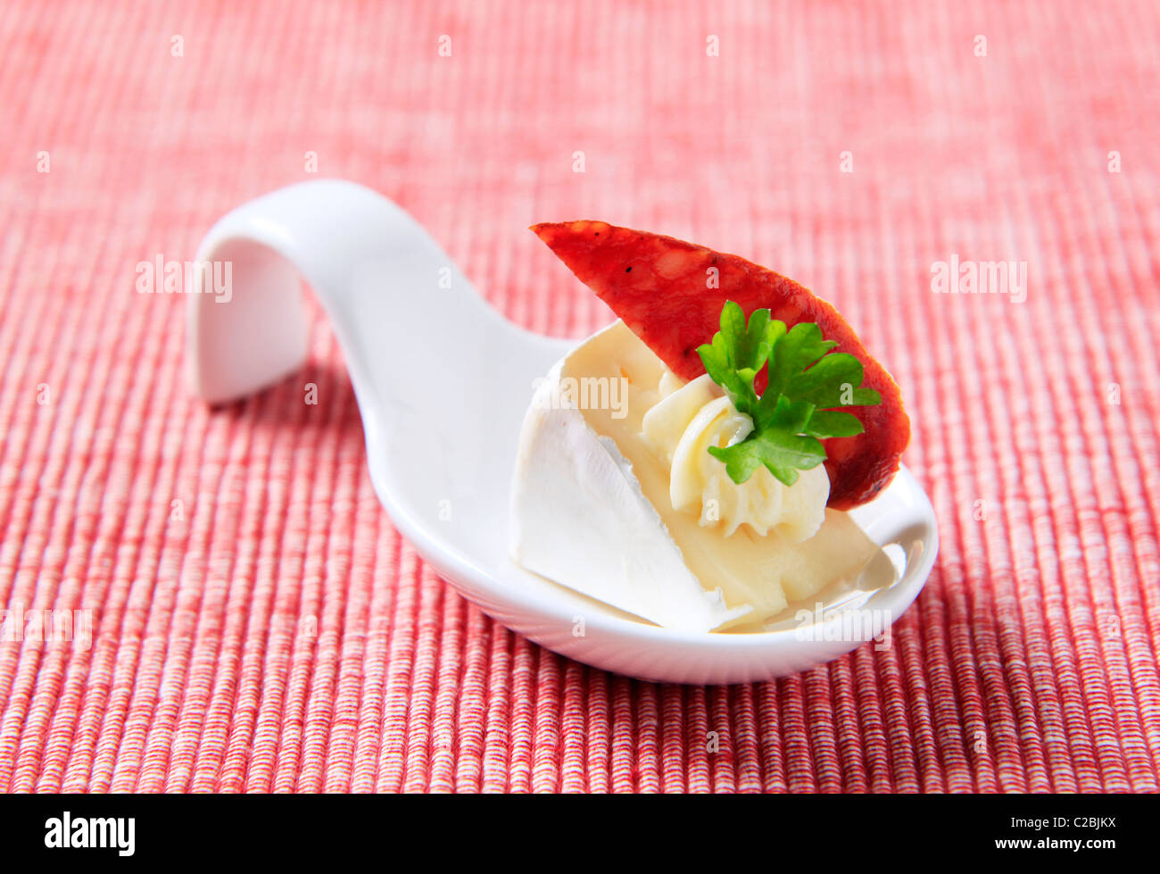 Formaggio antipasti su un cucchiaio di porcellana Foto Stock