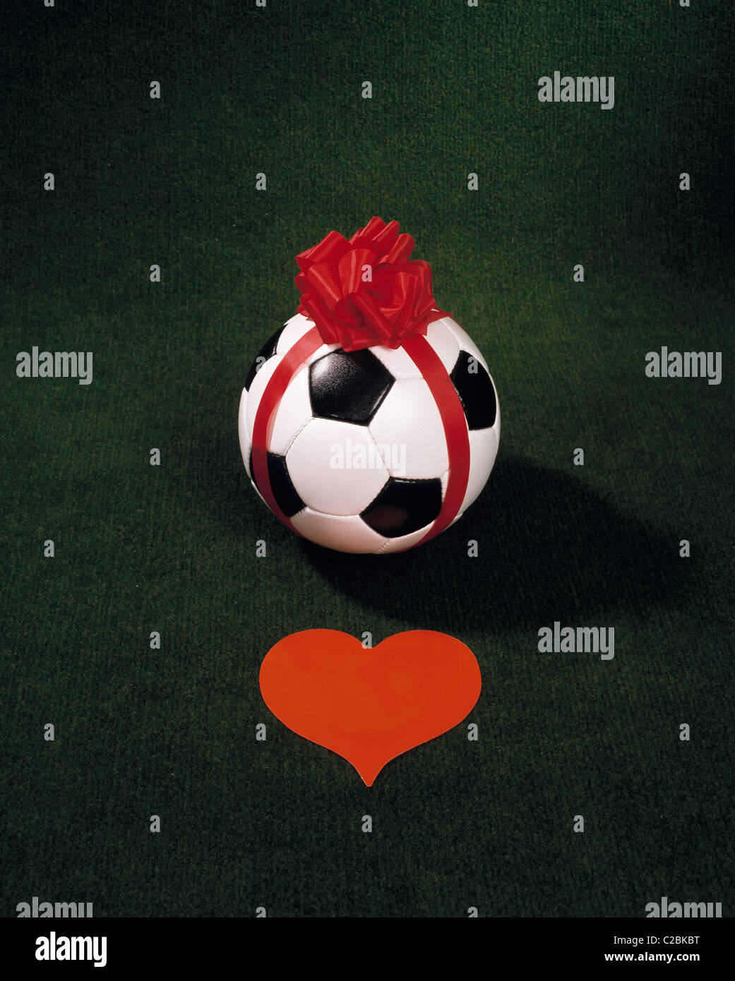 Sport, calcio, fotografia simbolica, sfera confezionato come un dono con un  rosso bowknot, prima che un cuore rosso, la passione del calcio, calcio  amore, linfa vitale Foto stock - Alamy