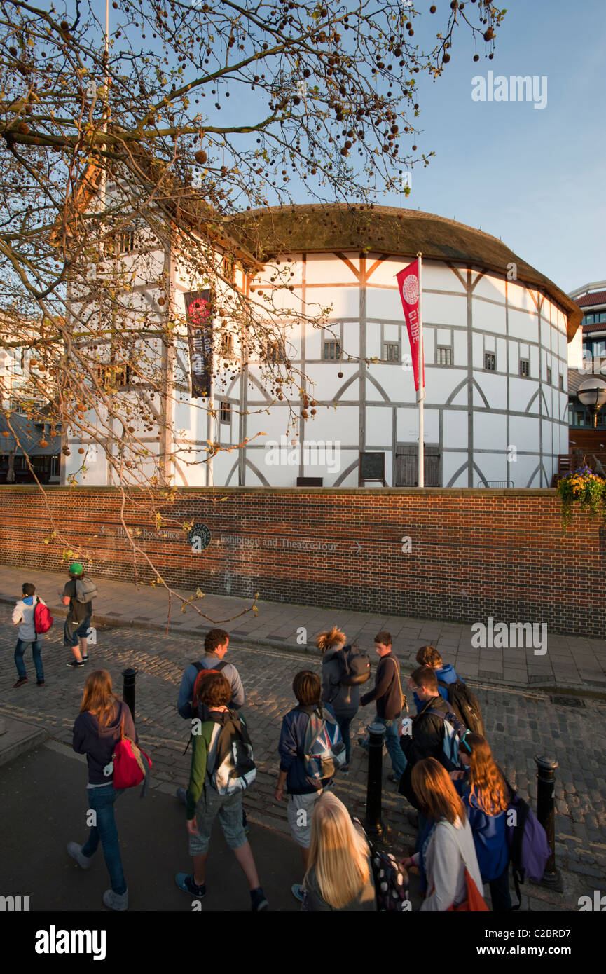 Il Globe Theatre di Shakespeare con una parte della scuola i bambini a piedi passato, a Londra, Inghilterra, Regno Unito. Foto Stock