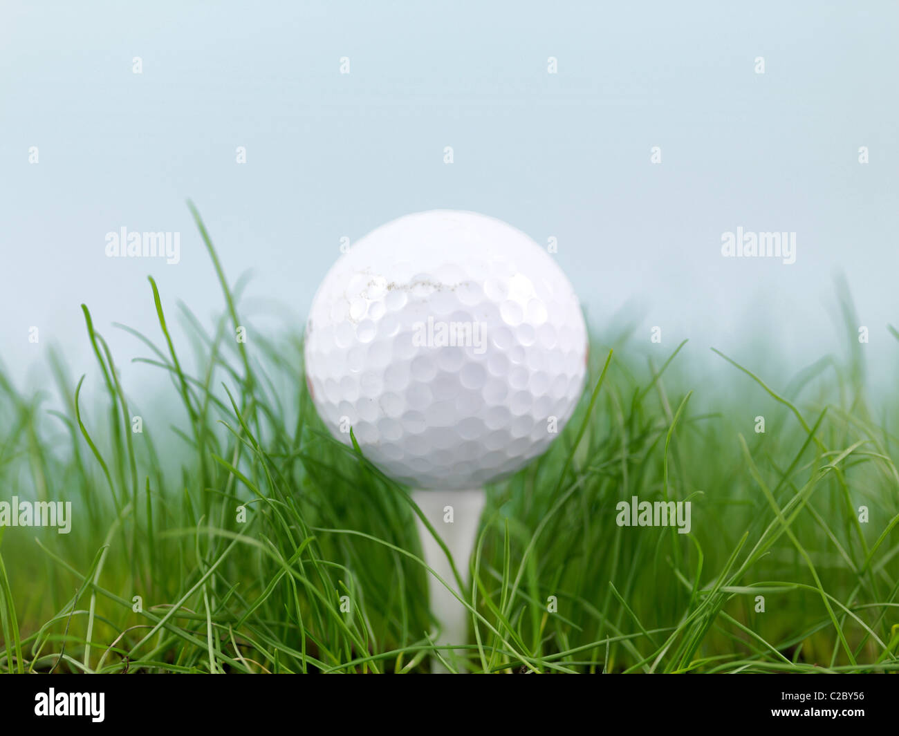 Una pallina da golf su erba verde siolated contro un cielo blu Foto Stock