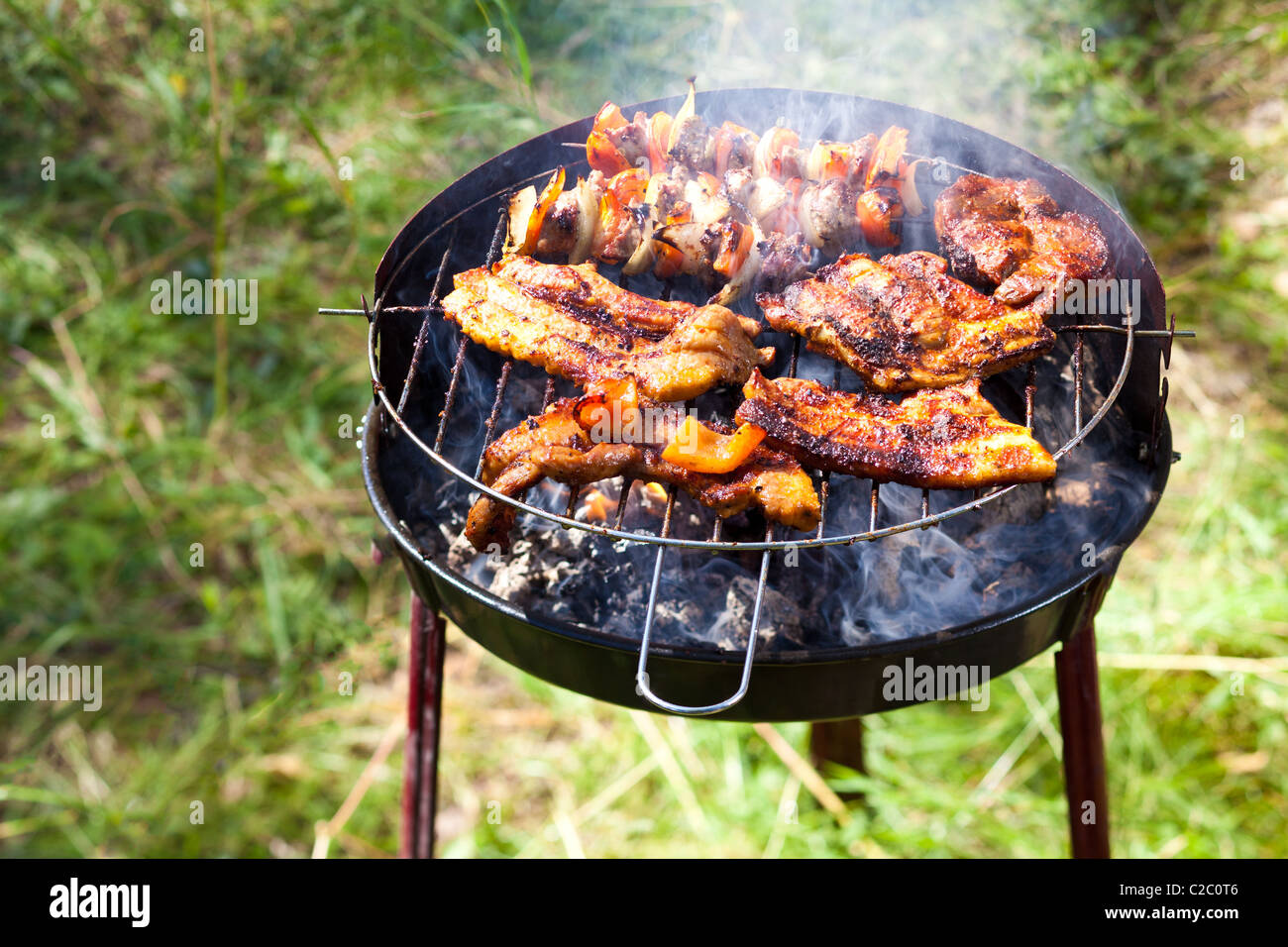 Succosa rib-eye per la cottura alla griglia, un bel po' di fumo visibile. Foto Stock