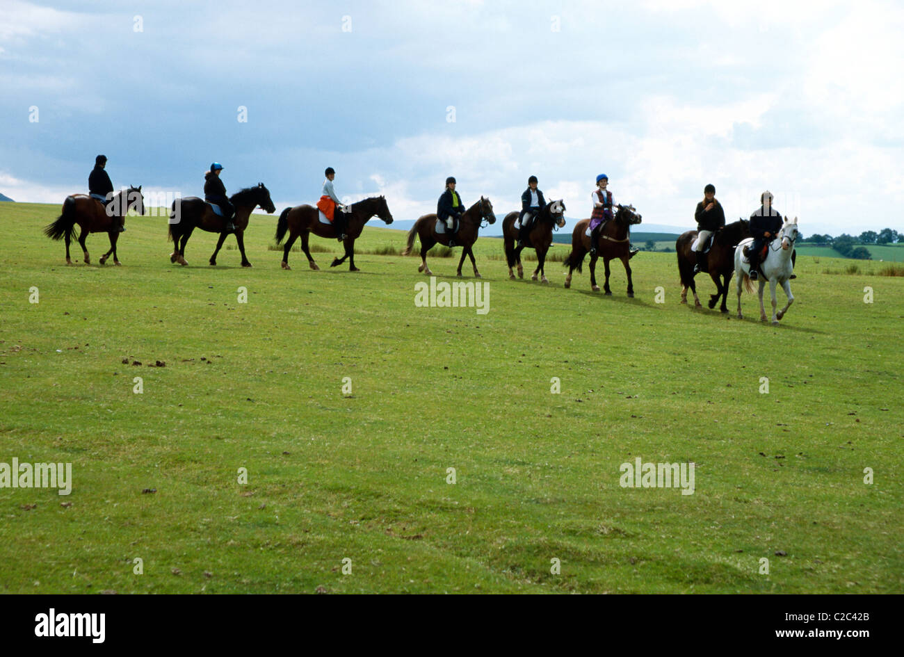 Percorsi per Pony una fila di piloti a cavallo su un pendio Foto Stock