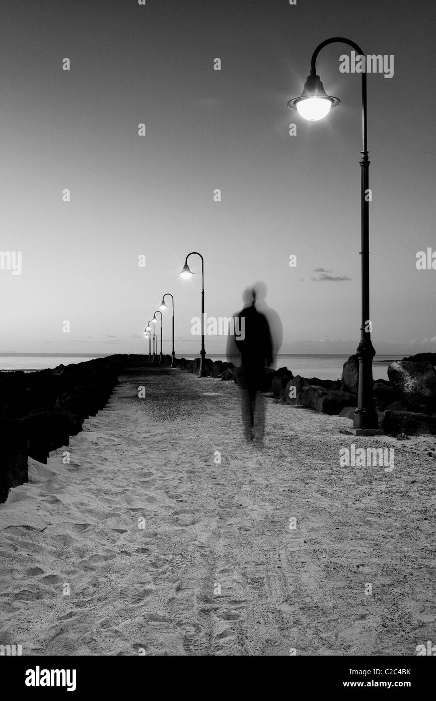 Lonely passeggiata serale lungo la riva Foto Stock