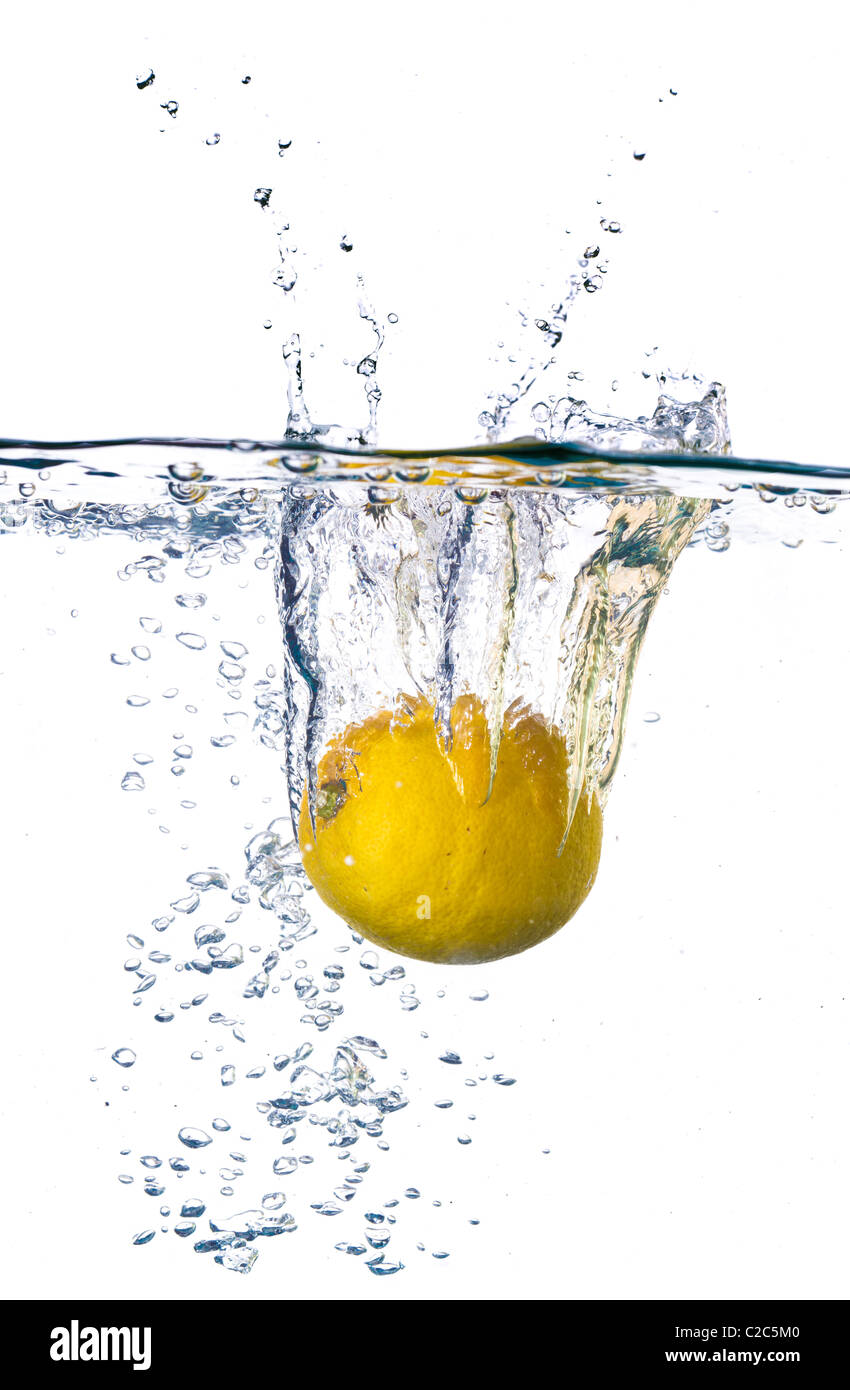 Il limone è scesa in acqua con splash isolato su bianco Foto Stock