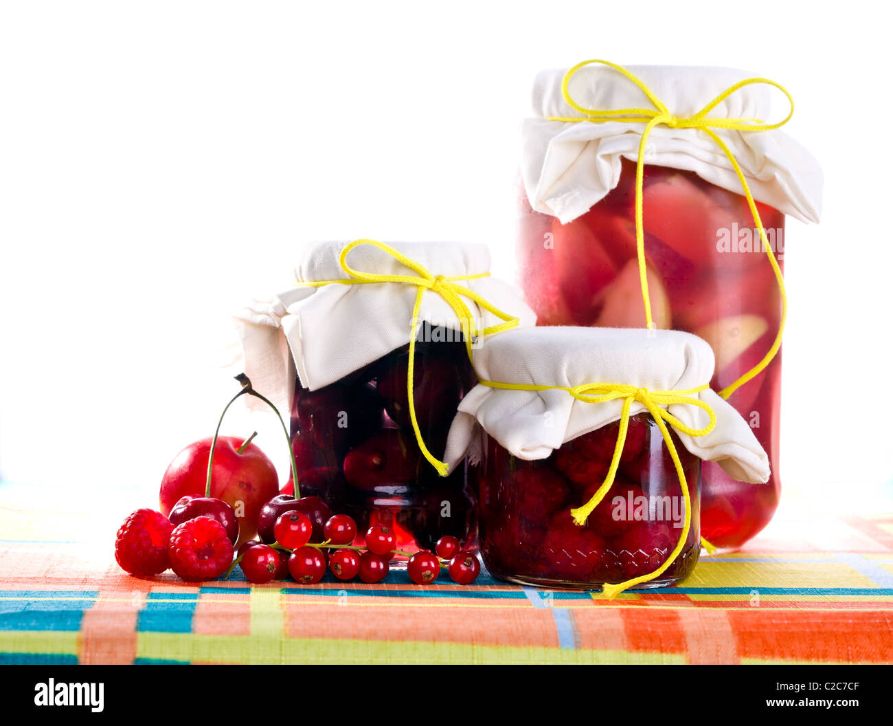I vasetti di confettura di lamponi, confettura di prugne e confettura di Apple su tavola, isolato su bianco. Foto Stock