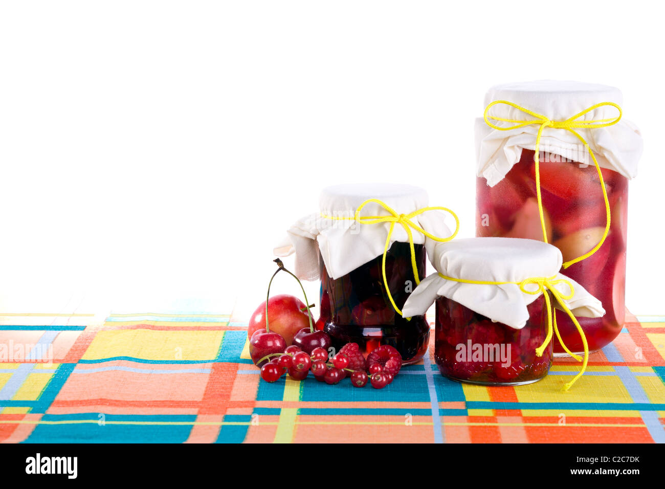 I vasetti di confettura di lamponi, confettura di prugne e confettura di Apple su tavola, isolato su bianco. Foto Stock