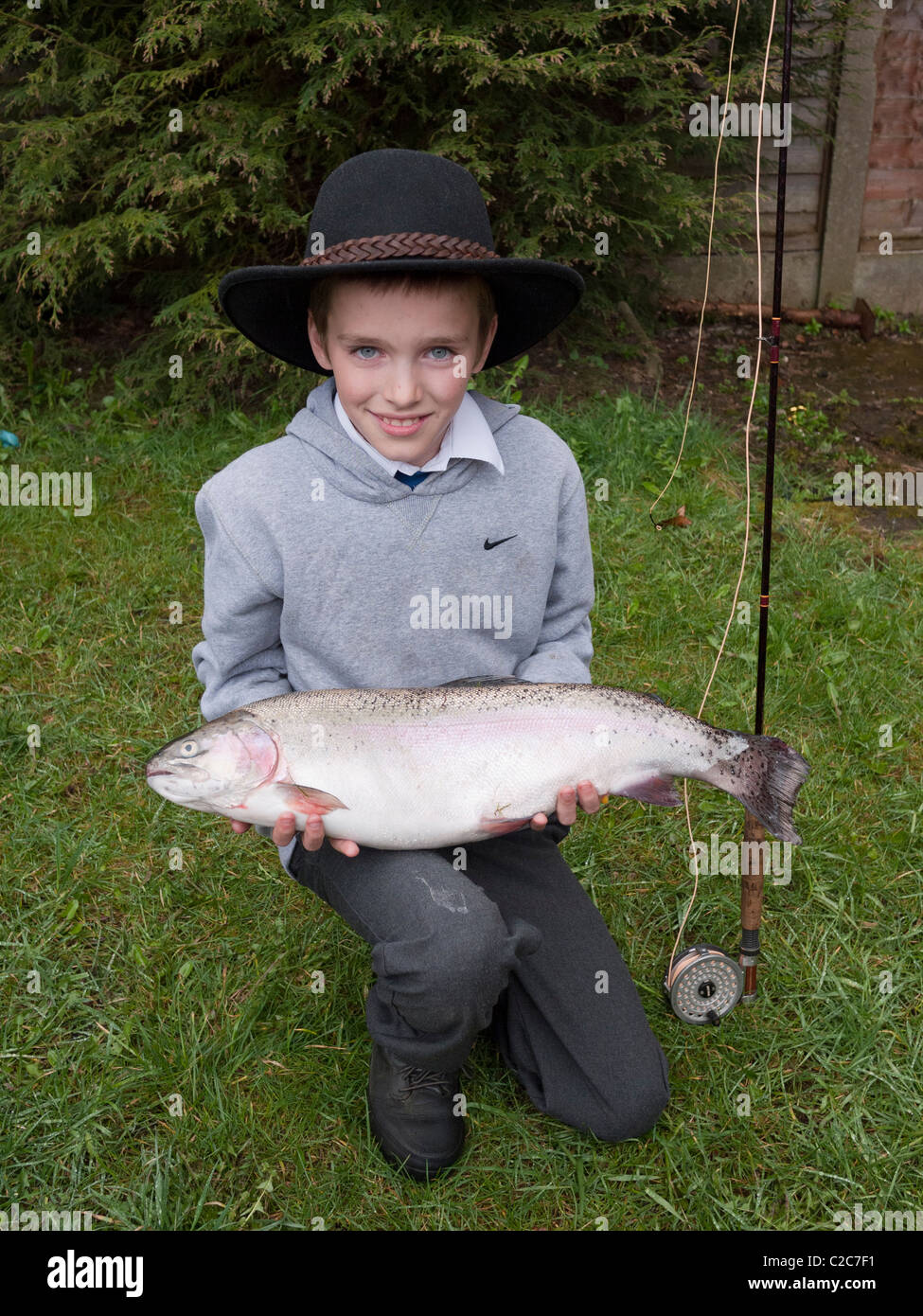 Ragazzo giovane (11 anni) con un 9lb della trota arcobaleno, Inghilterra, Regno Unito. Foto Stock