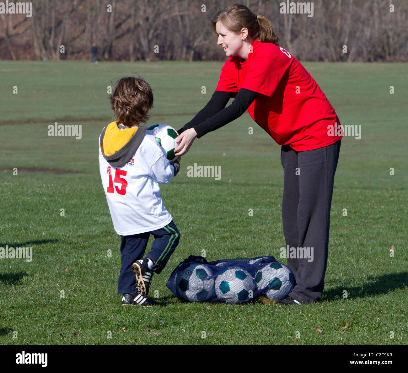 Molto giovani e bambini che giocano e di essere istruito nel calcio. Foto Stock