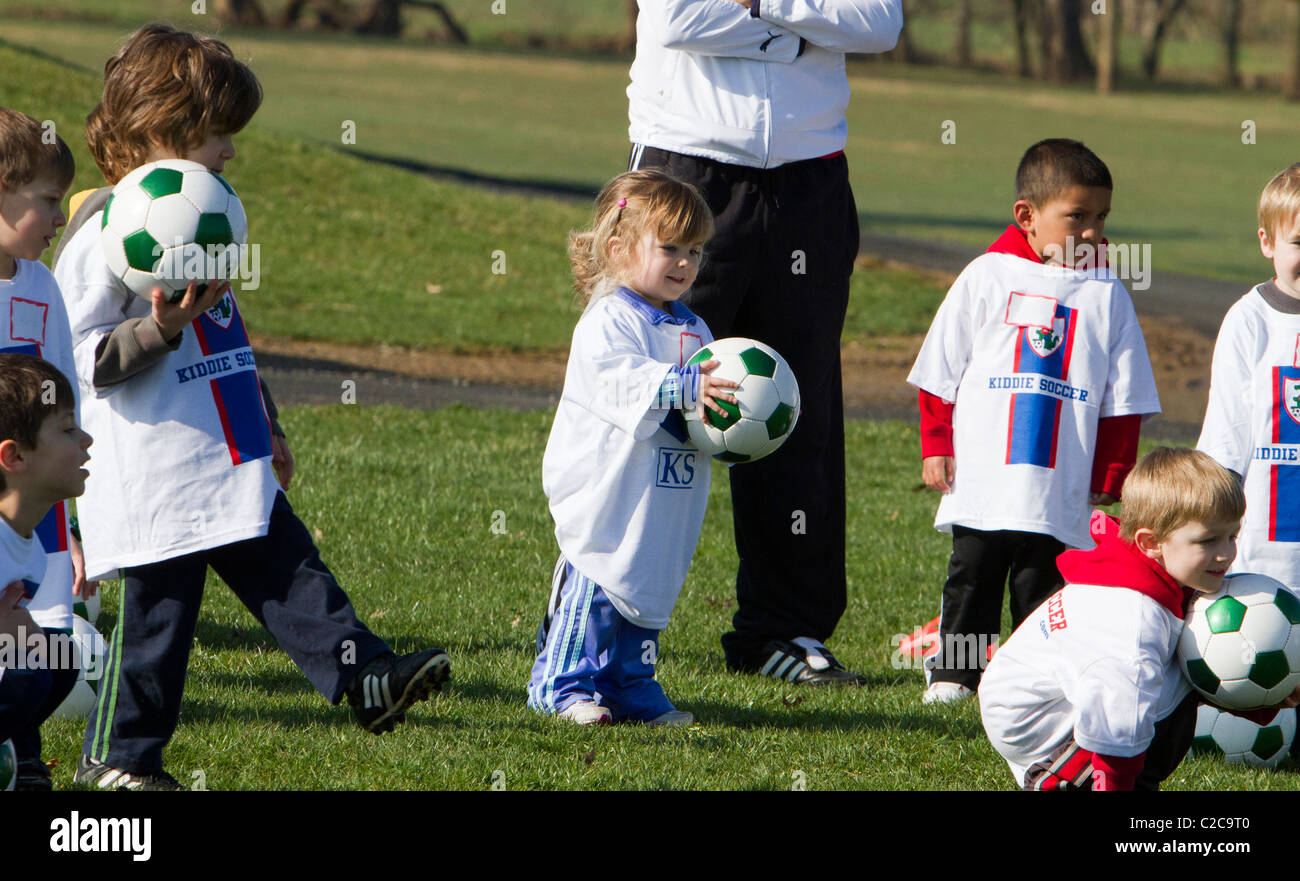 Molto giovani e bambini che giocano e di essere istruito nel calcio. Foto Stock