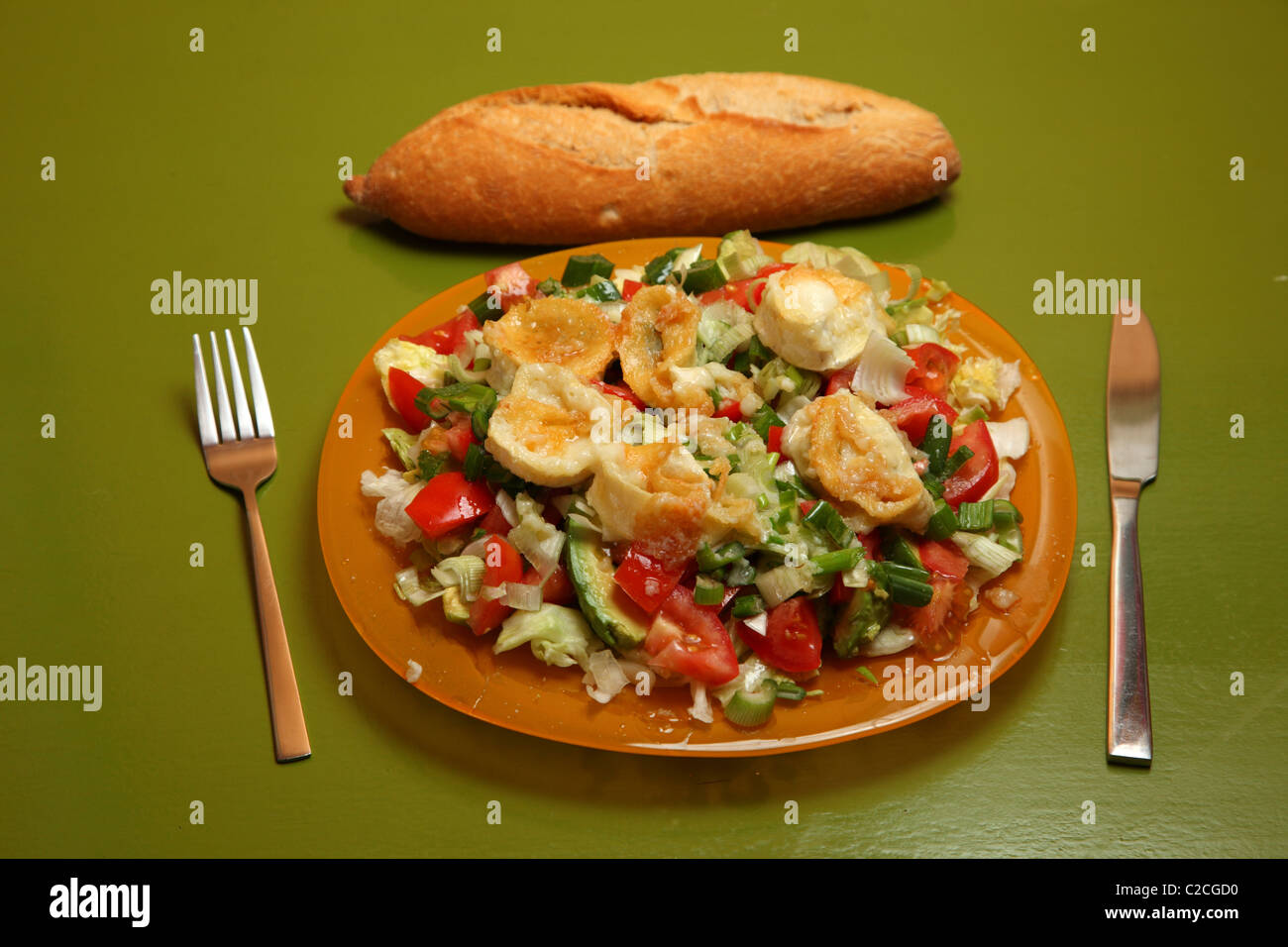 Piastra con insalata e pane sulla tavola Foto Stock