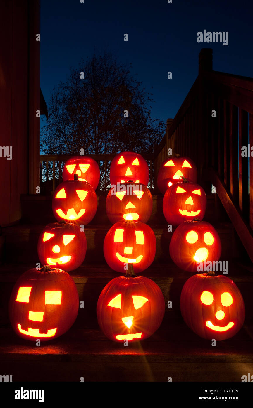 Zucche illuminate sui gradini di una casa di Halloween Foto Stock