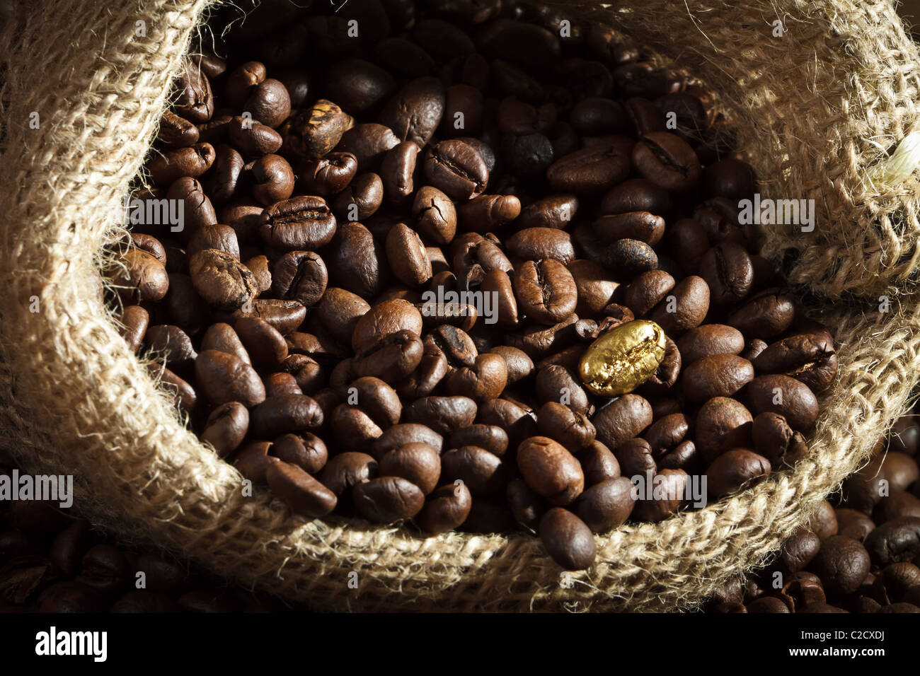 Golden semi di caffè su tela di sacco di caffè Foto Stock
