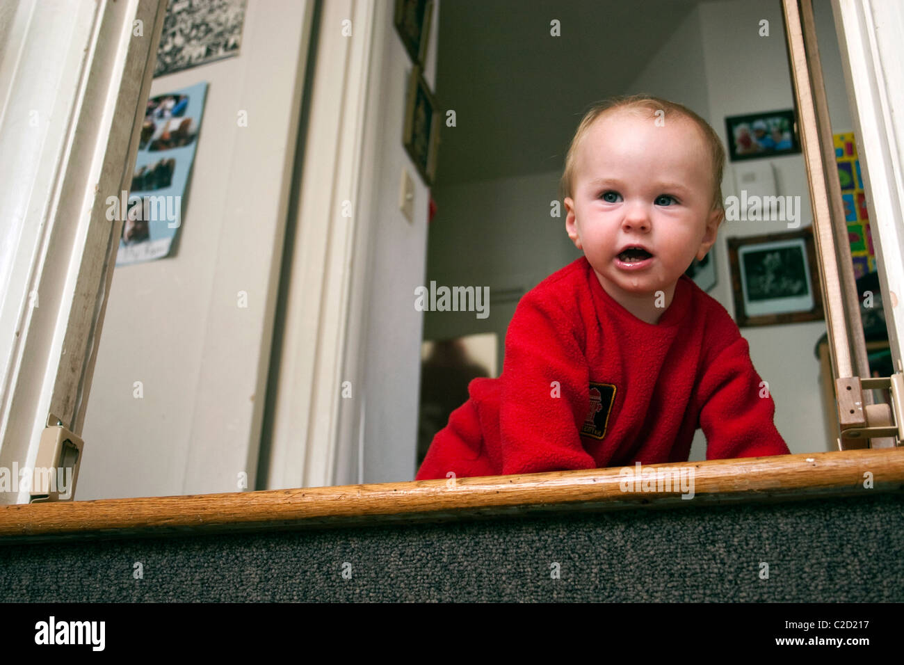 Un bambino tiene il bambino porta di sicurezza e poi strisciando giù per le scale. Foto Stock