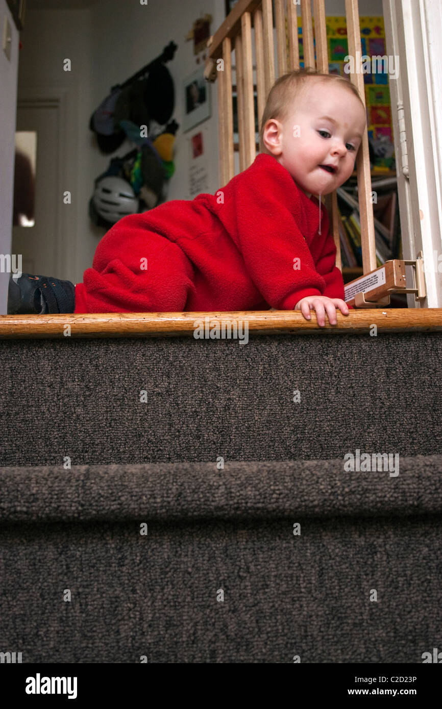 Un bambino tiene il bambino porta di sicurezza e poi strisciando giù per le scale. Foto Stock