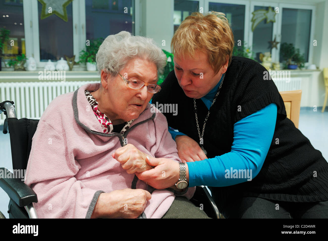 Persone, handicap fisici, la vecchiaia, la casa di riposo, Altenzentrum der St. Clemens Hospitale in Sterkrade, donna anziana seduto nella sedia a rotelle, di età compresa tra i 70 e 85 anni, la demenza malattia, un infermiere trattiene la sua mano, di età compresa tra i 50 e i 60 anni, Waltraut, Elke, D-Oberhause Foto Stock
