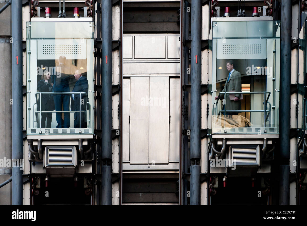 In acciaio inox e ascensori di vetro del Lloyds insurance edificio nella città di Londra Foto Stock