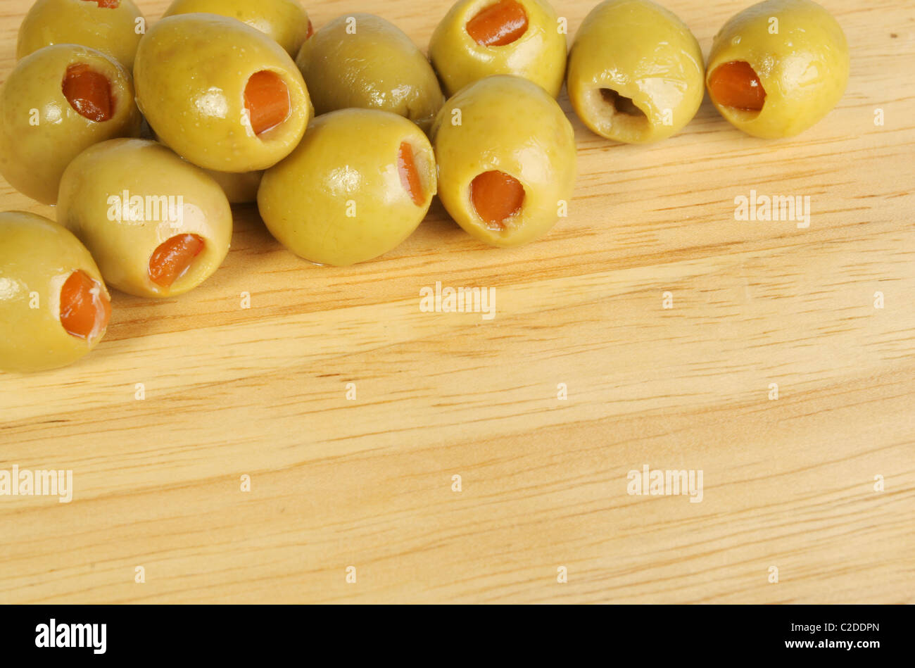 Un gruppo di Olive farcite in un angolo del legno di un preparato alimentare board Foto Stock