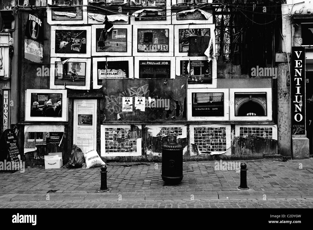 Un decrepito edificio sulla Rue du Marché aux Herbes, Bruxelles/Grasmarkt, Bruxelles, Belgio, coperto di poster Foto Stock