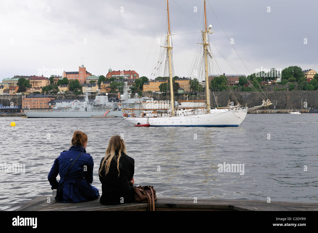 Due giovani donne guardando verso delle navi nel porto di Stoccolma Stockholms Lan, Svezia Foto Stock