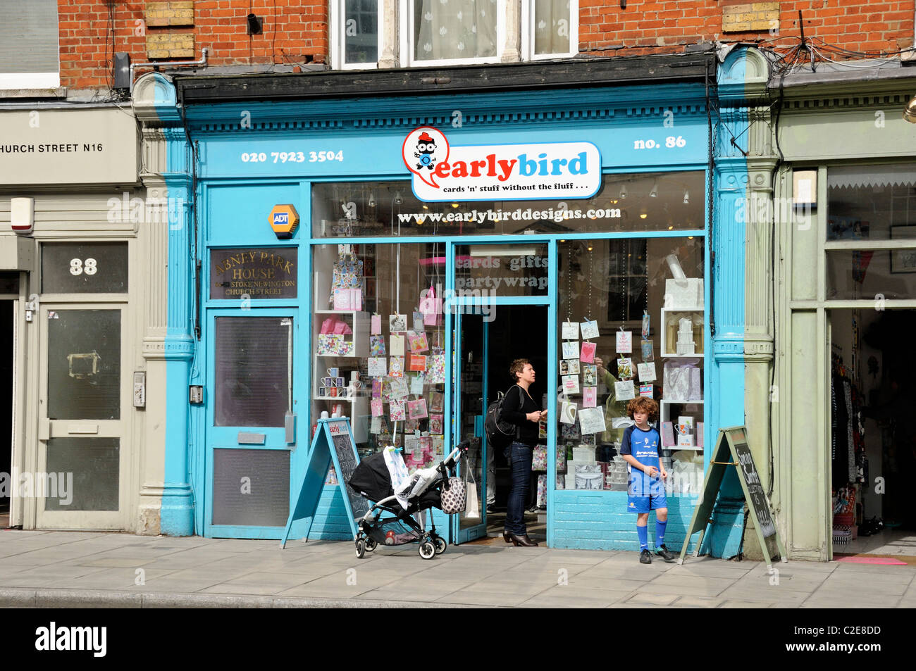 Le persone al di fuori del negozio Earlybird a Stoke Newington Church Street Hackney Londra Inghilterra REGNO UNITO Foto Stock