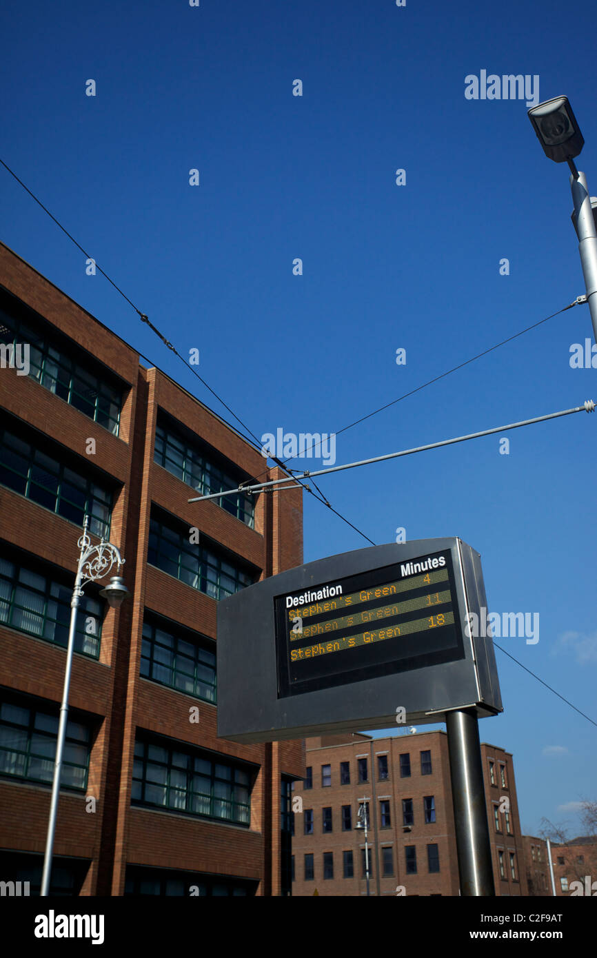 Linee di alimentazione aeree per Luas tram e treni per aspirare con uffici commerciali in background Foto Stock