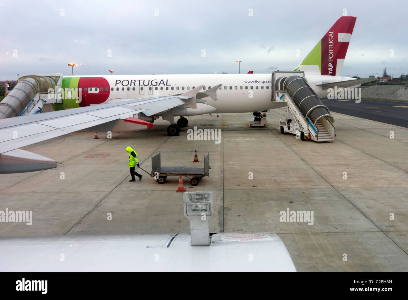 Toccare airplane e gestore di borsa presso l'aeroporto di Portela pista a Lisbona, Portogallo Foto Stock