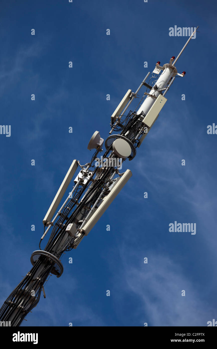 Una torre di telecomunicazioni con piatti a microonde e antenne di telefonia mobile Foto Stock