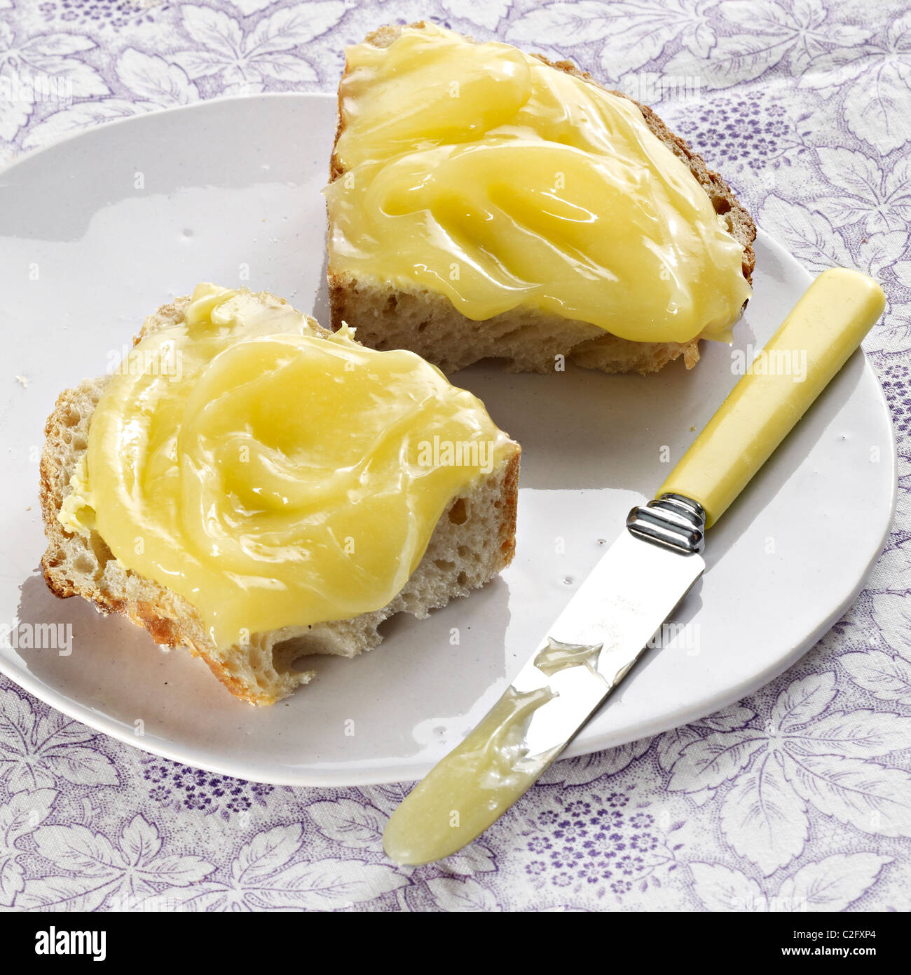 Cagliata di limone sparsa spessa su pane Foto Stock