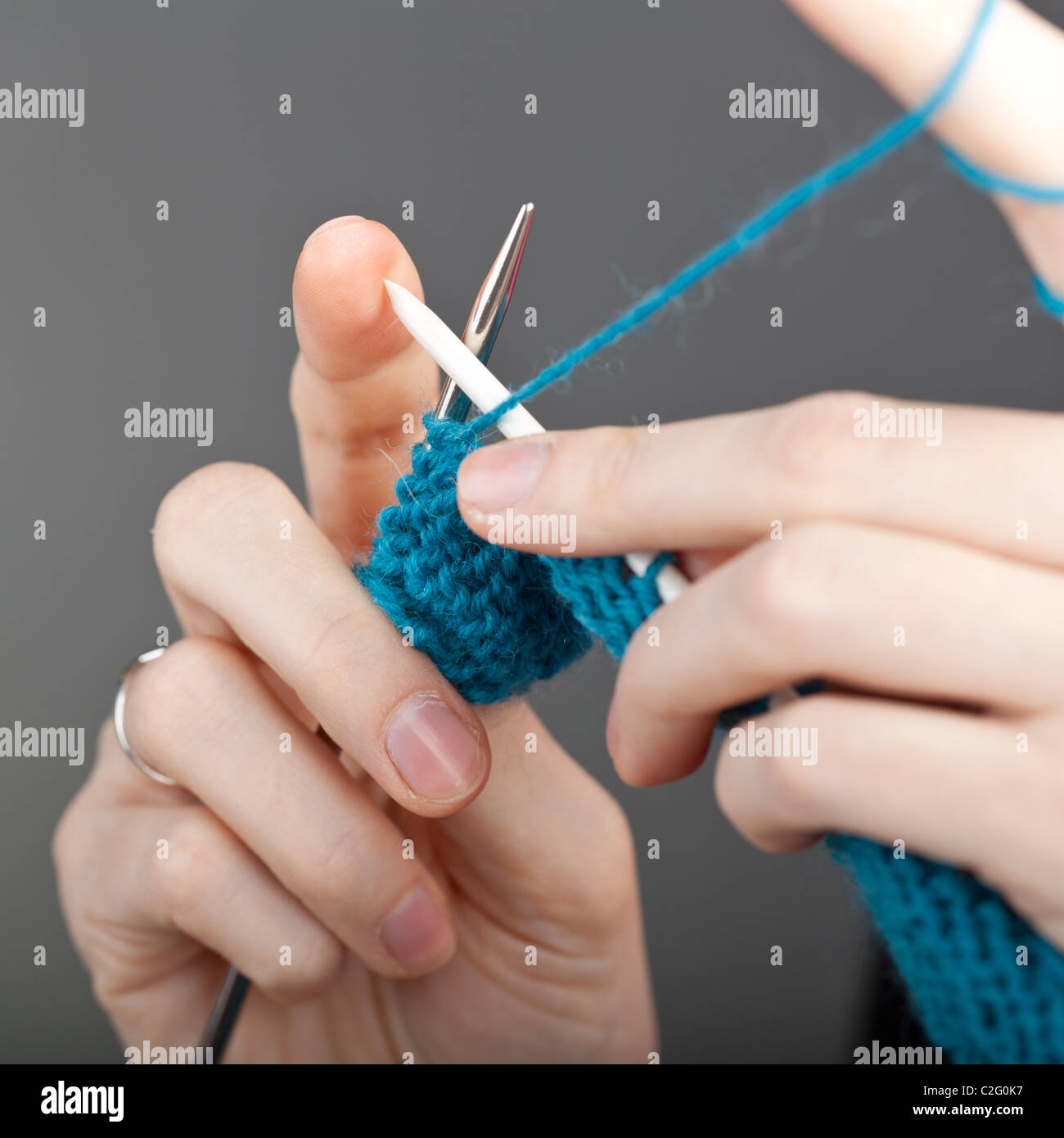 Le mani di una giovane donna con maglia di lana blu Foto Stock