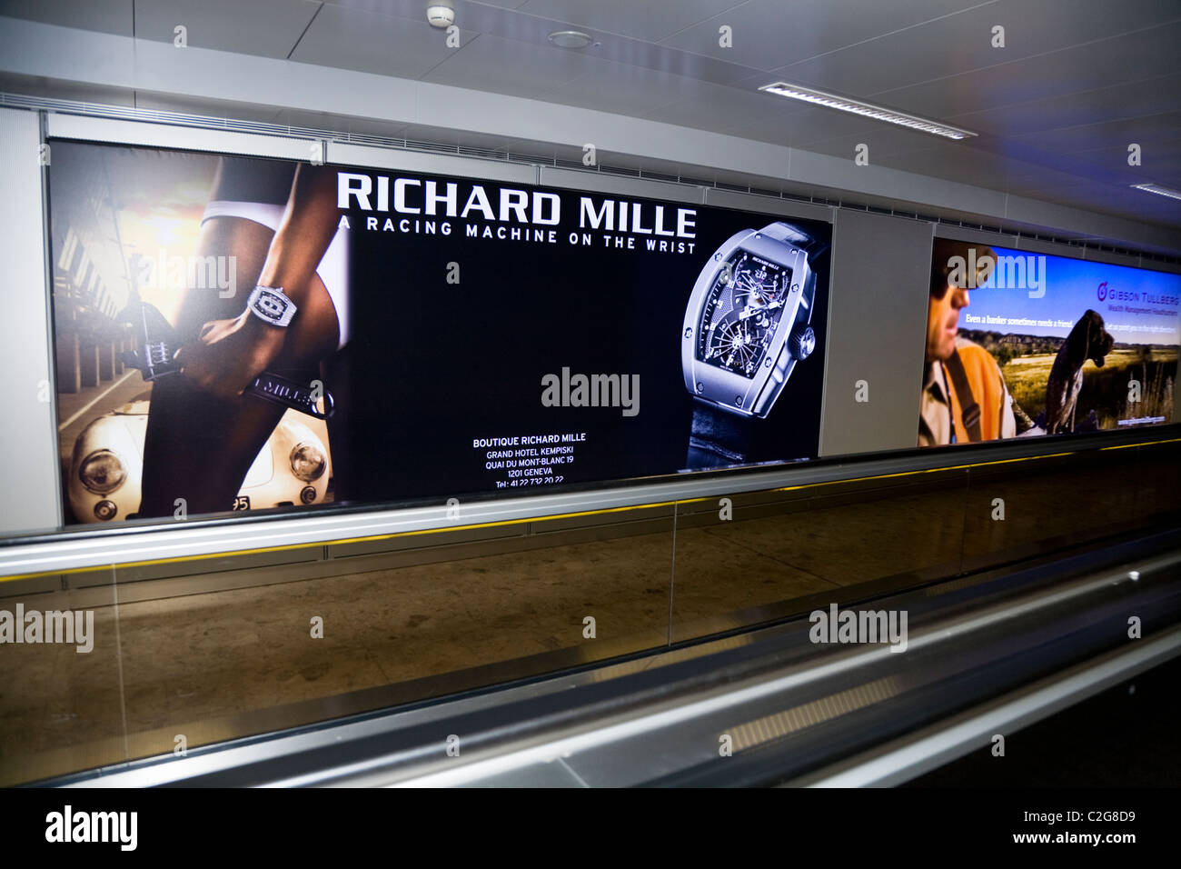 Guardare la pubblicità / pubblicità segno / poster al terminal internazionale sala partenze, Ginevra / Geneve 'Cointrin' aeroporto, Svizzera. Foto Stock