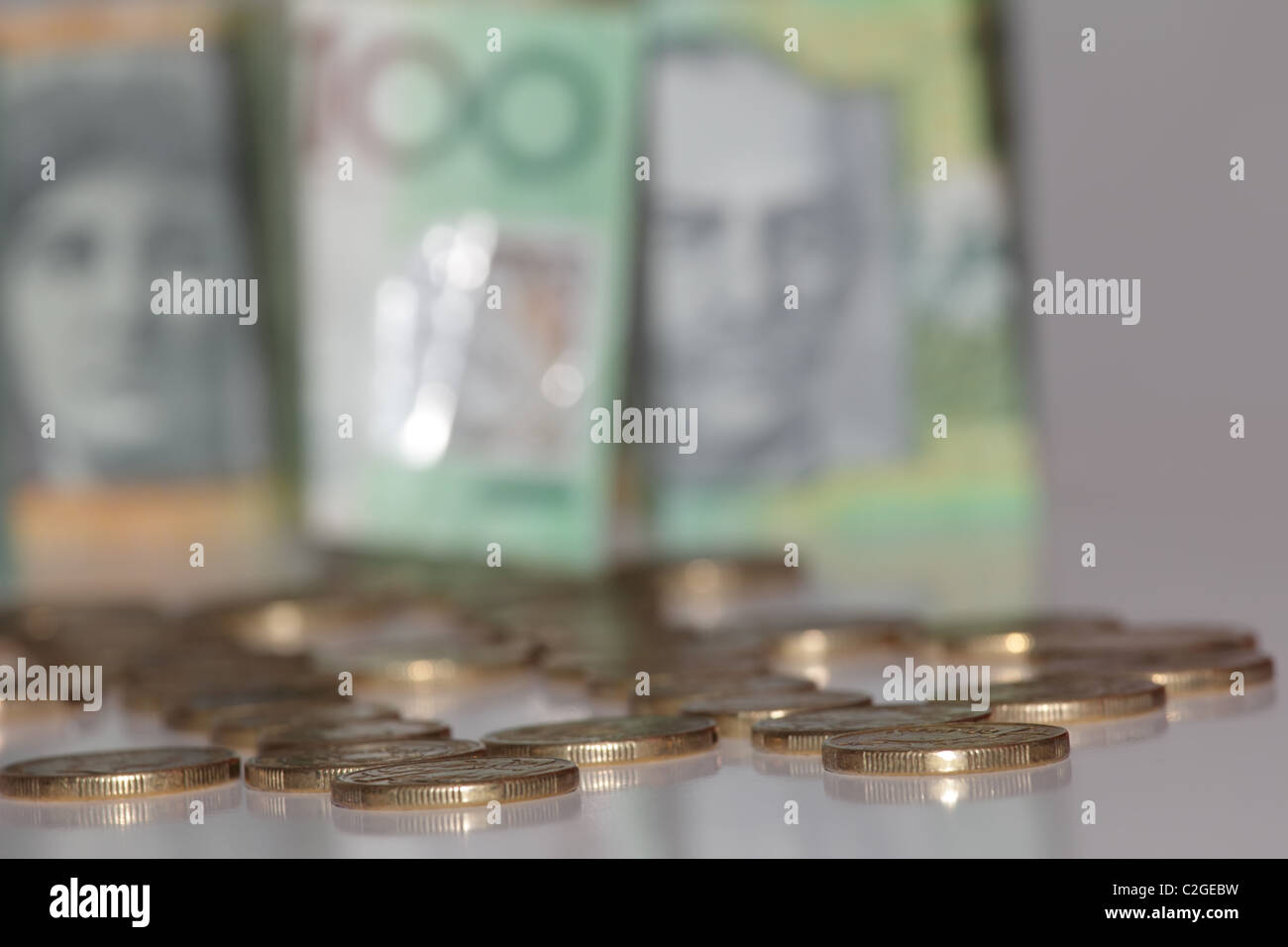 Australian Gold monete con la riflessione sulla tavola con un centinaio di Australian Dollar Bills Foto Stock