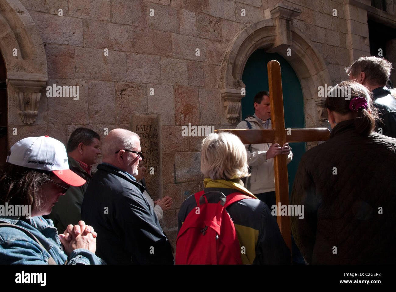 Gruppo di pellegrini con croce di legno al VI stazione della Via crucis. Gerusalemme la città vecchia Foto Stock