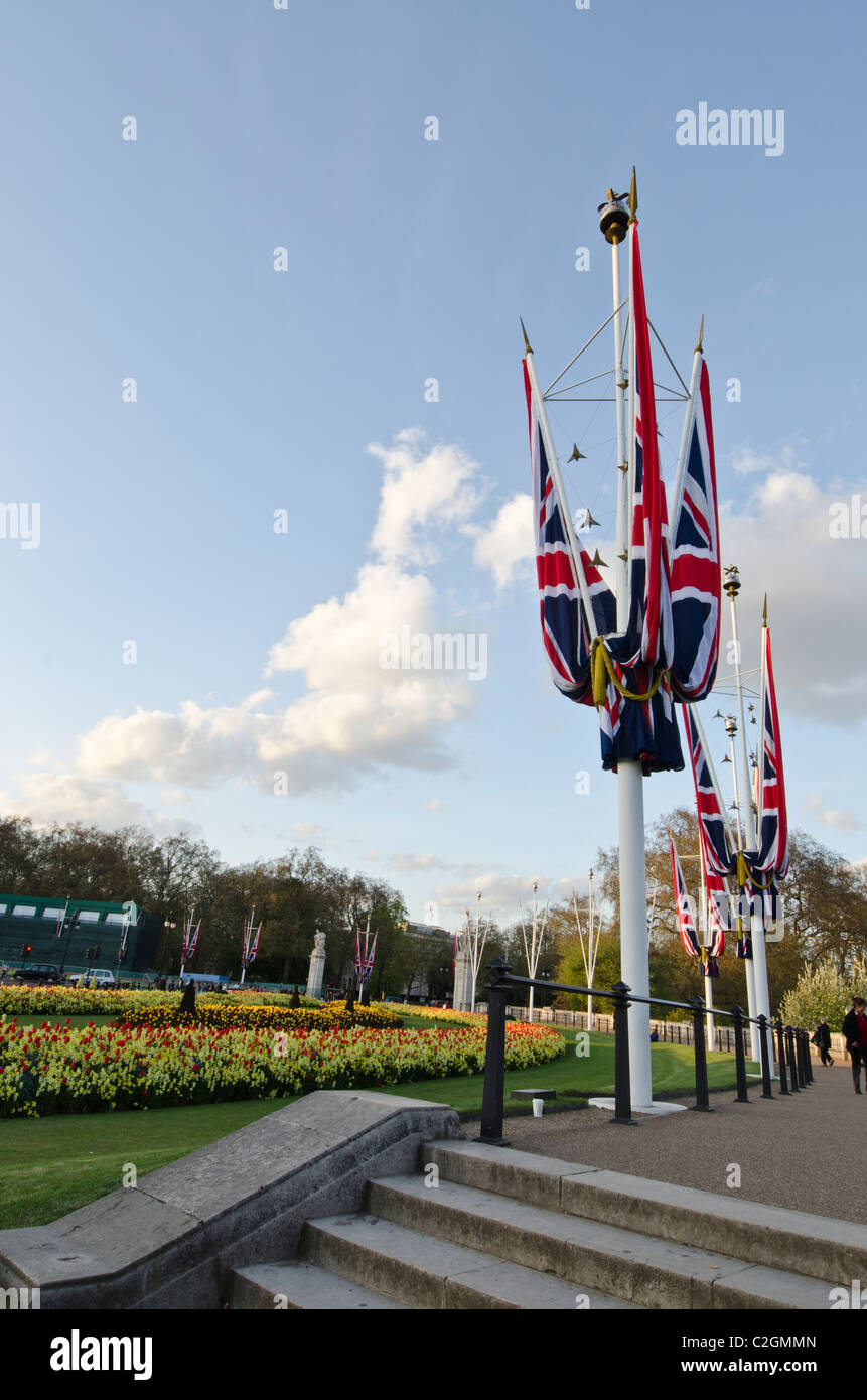 Union Jack flag su pali molla formale di biancheria da letto di fiori piante. Al di fuori del Palazzo di Buckingham Foto Stock