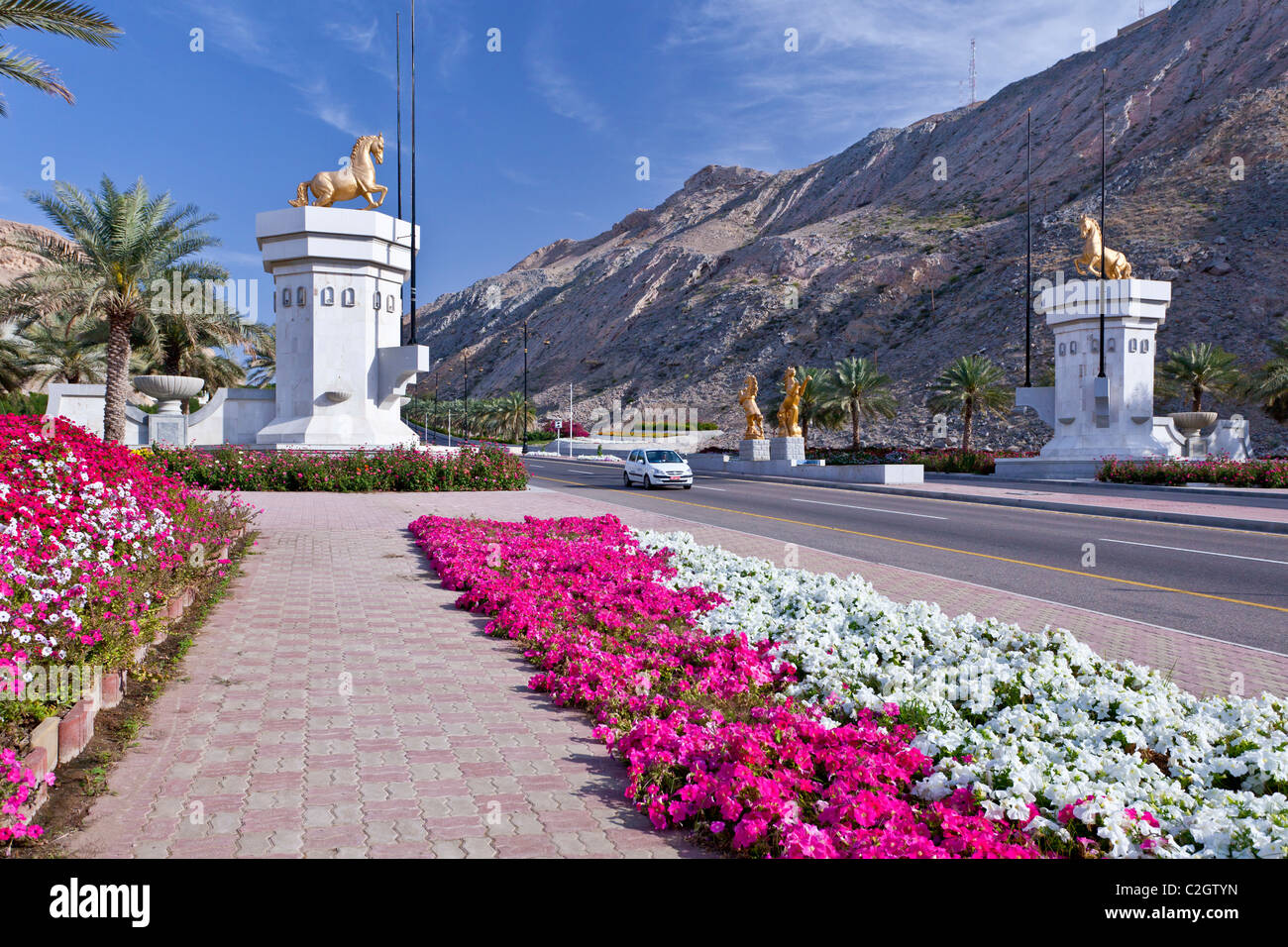Strade strade e decorato con fiori e un cavallo cancello di ingresso in Muscat Oman. Foto Stock