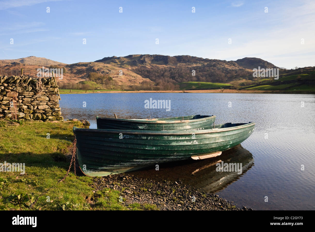 In legno barche da pesca sulla riva del Watendlath Tarn nelle brughiere del Parco Nazionale del Distretto dei Laghi. Watendlath, Cumbria, Regno Unito, Gran Bretagna Foto Stock