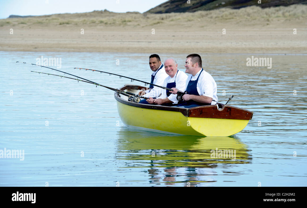 Westcountry chef Rick Stein, Nathan fuorilegge e Michael Caines sat in una barca con canne da pesca, Camel estuary, Padstow Cornwall Foto Stock