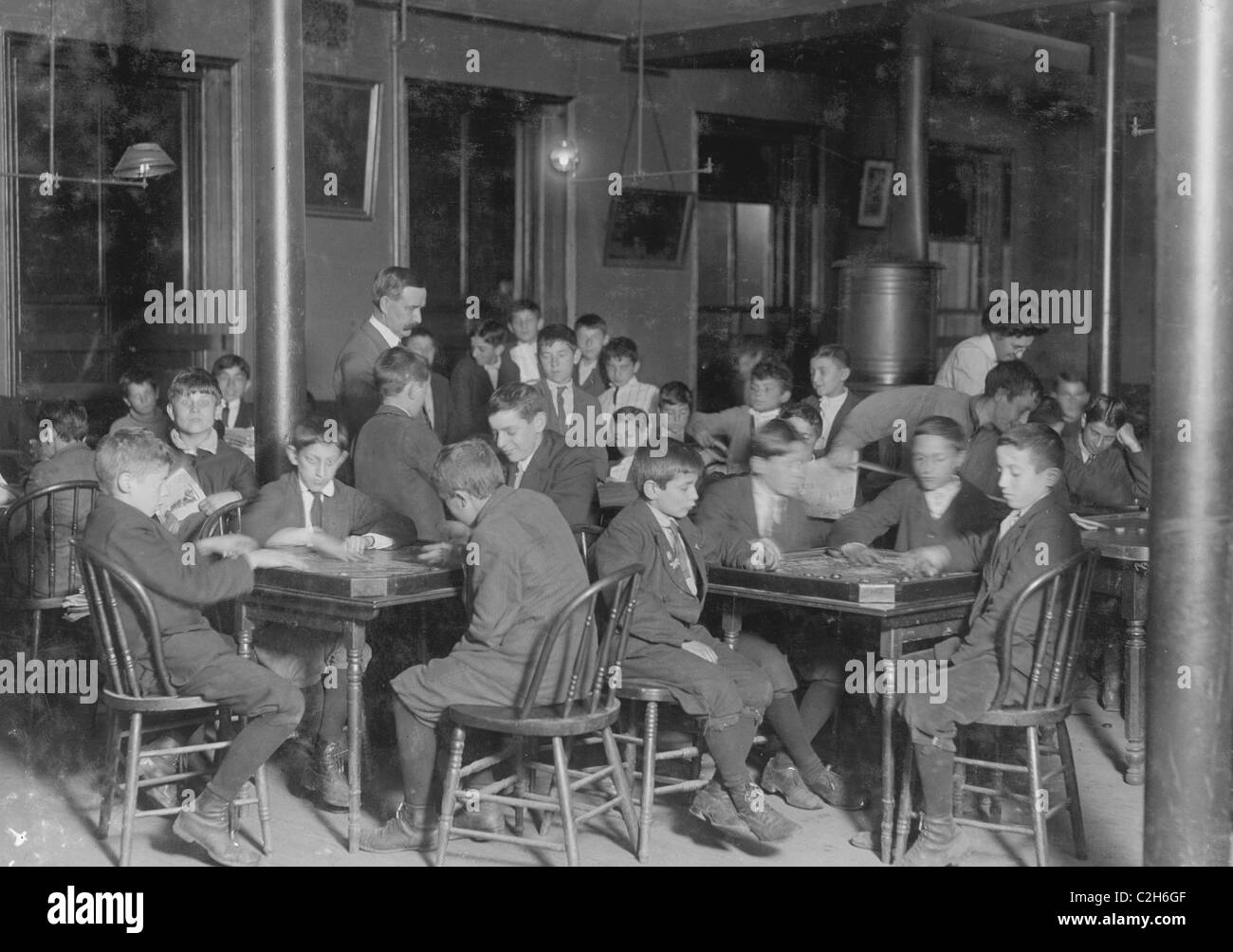 In Newsboys sala lettura. Ragazzi seduti ai tavoli a giocare i giocatori. Foto Stock