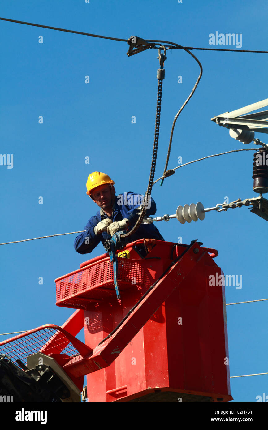 Elettricista lavorando sulla sommità di una torre Foto Stock