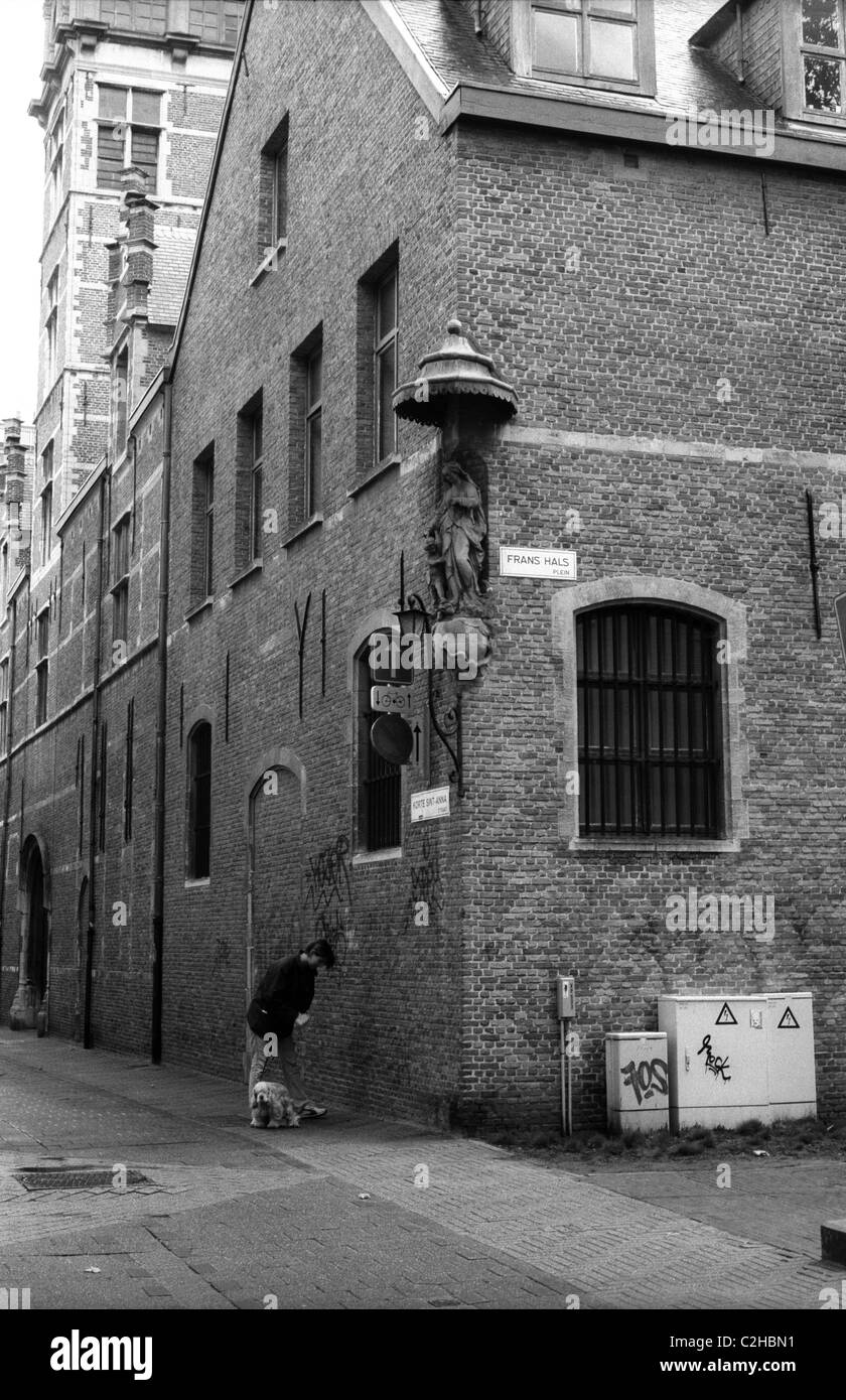 Donna che cammina cane sotto una Maria effigy ad Anversa, Belgio Foto Stock