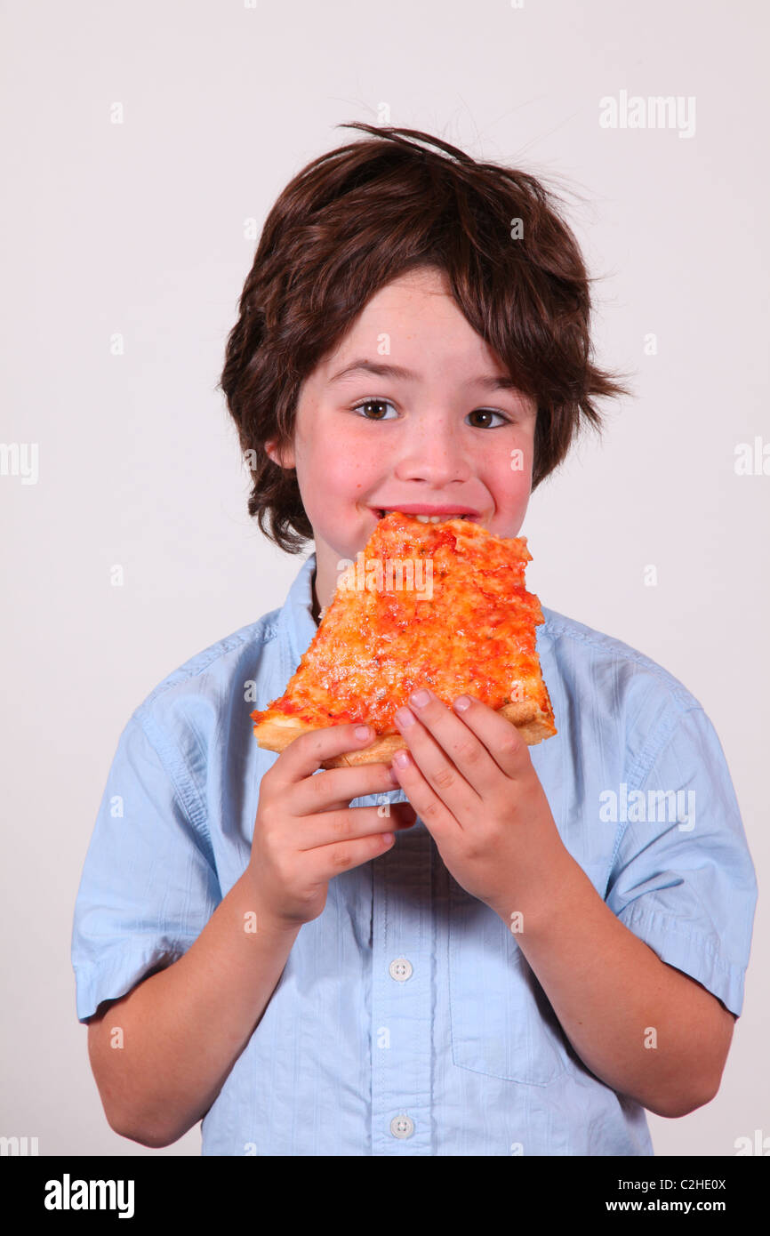Ragazzo di prendere un boccone fuori di una fetta di formaggio pizza Foto Stock