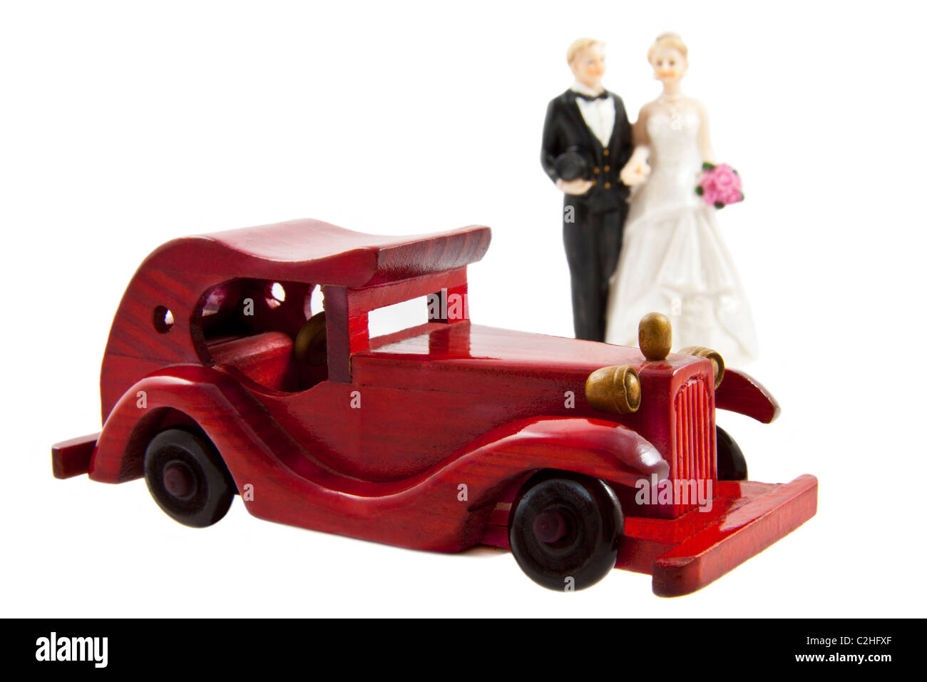 Coppia sposata dietro un auto rossa isolato su bianco Foto Stock