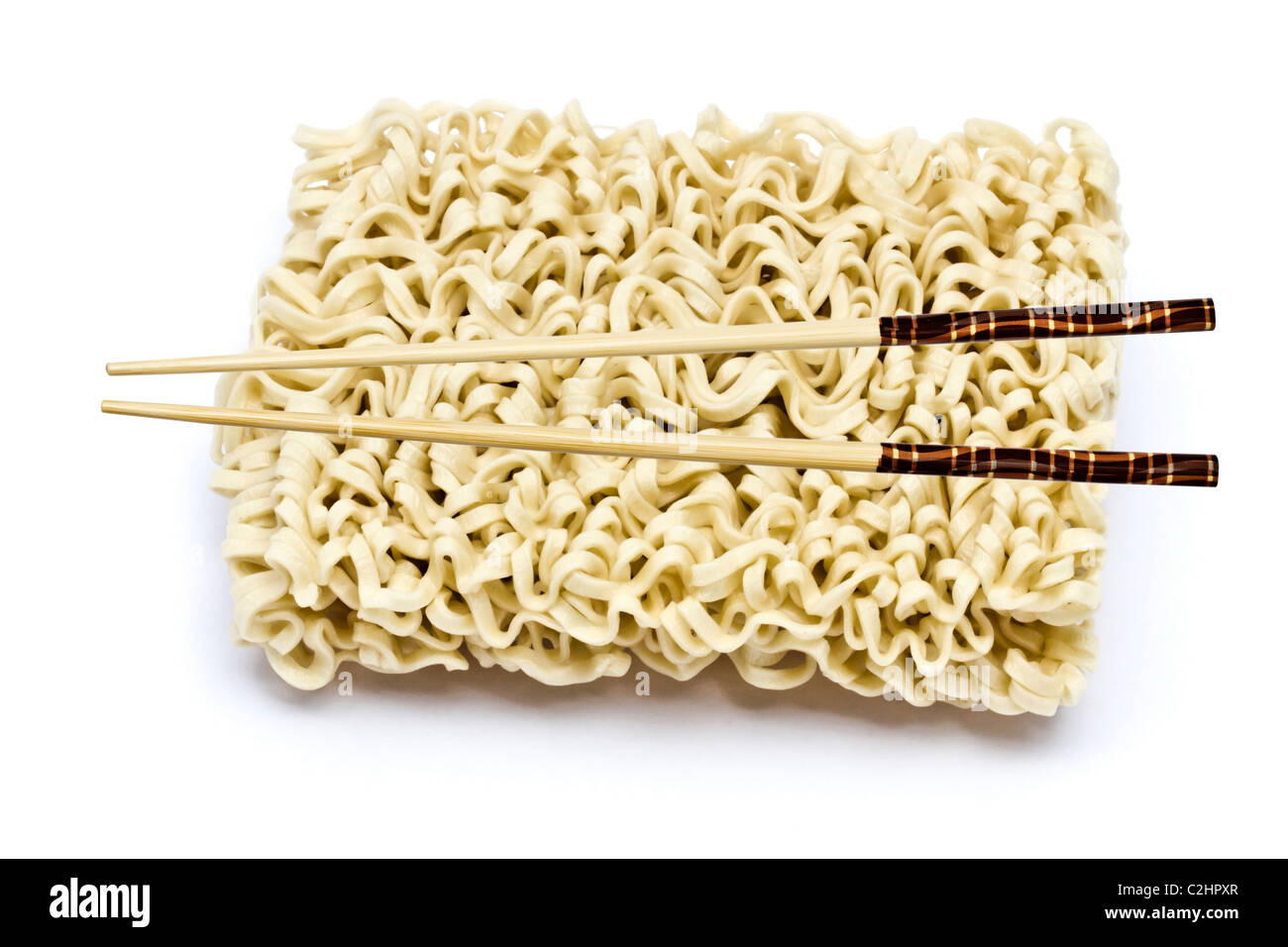 Un blocco di spaghetti istantanei e bastoncini closeup su bianco Foto Stock