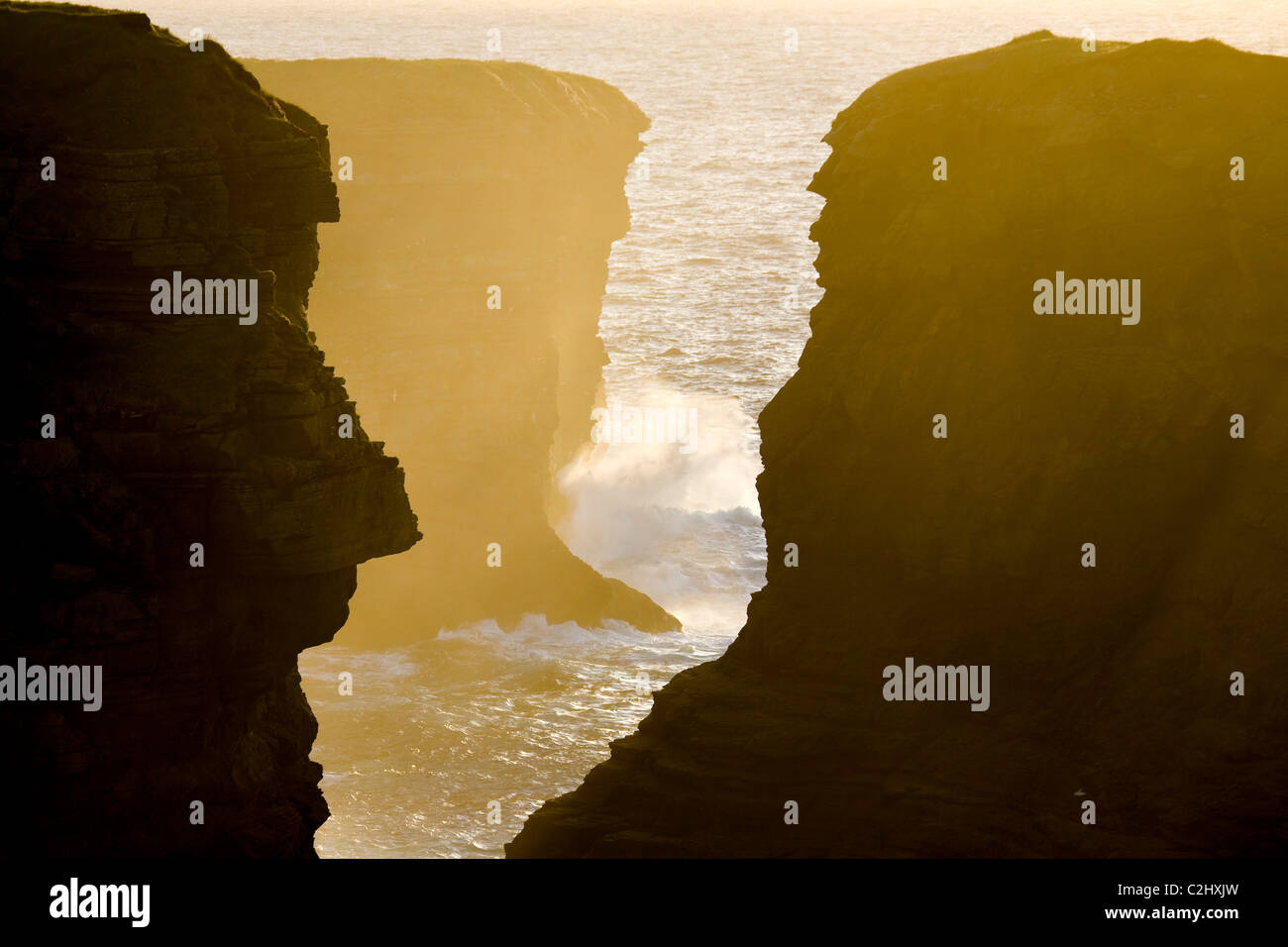 Il tramonto si accende un abisso in Atlantico scogliere vicino alla testa di Loop, County Clare, Irlanda. Foto Stock