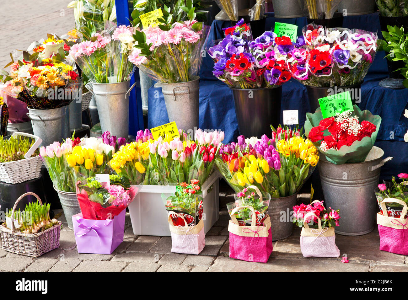 Display floreali di tagliare i grappoli e mazzi di fiori di primavera al di fuori di un fioraio in Inghilterra, Regno Unito Foto Stock