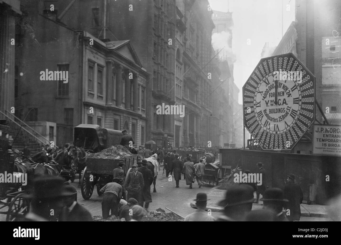 I carri trundle lungo le strade di Manhattan passato un YMCA segno di orologio Foto Stock