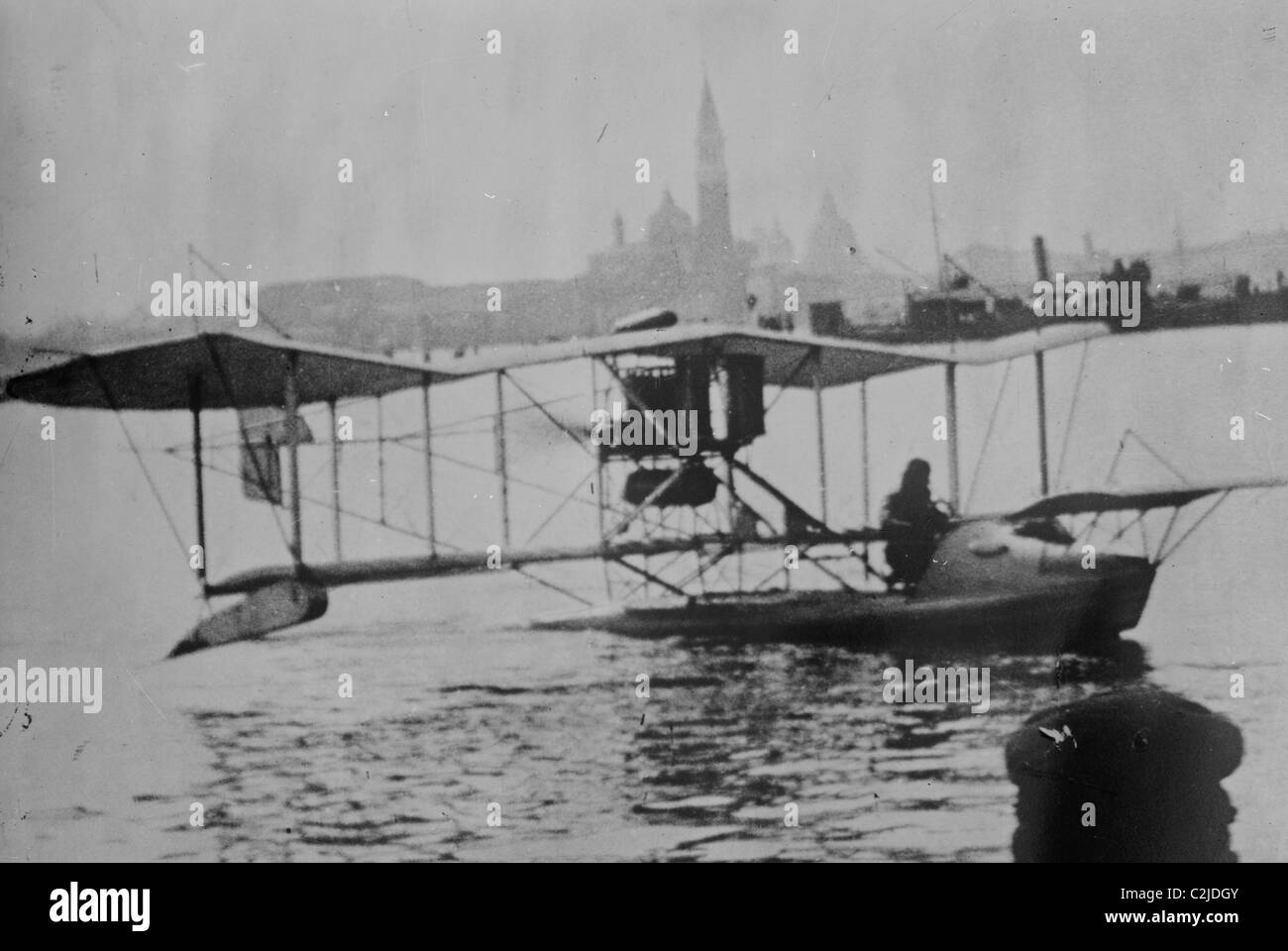 Terra biplanare nei canali di Venezia; capitano del ginocchio in aereo Foto Stock