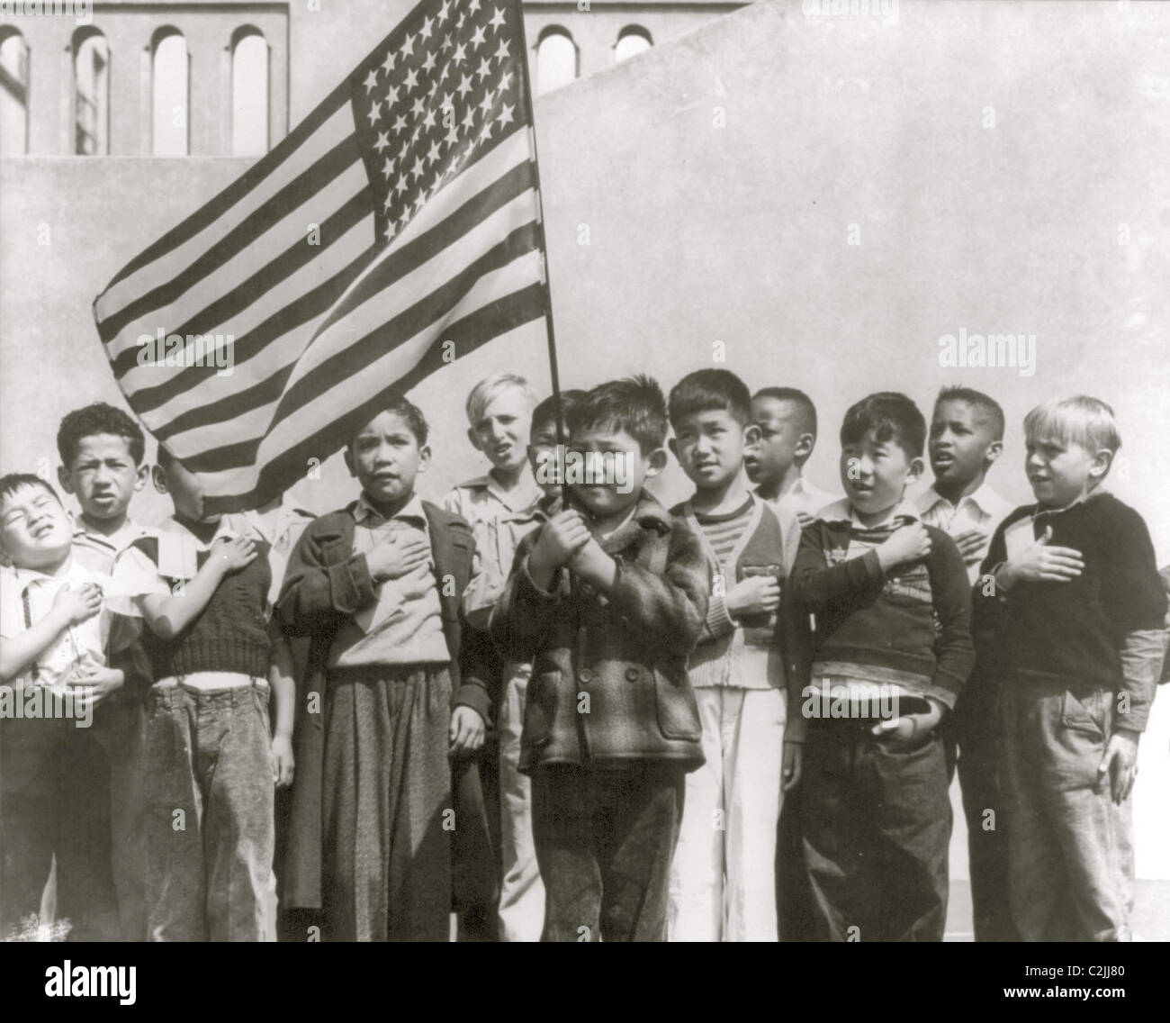 Insediamento internazionale bambini salutare la bandiera americana Foto Stock