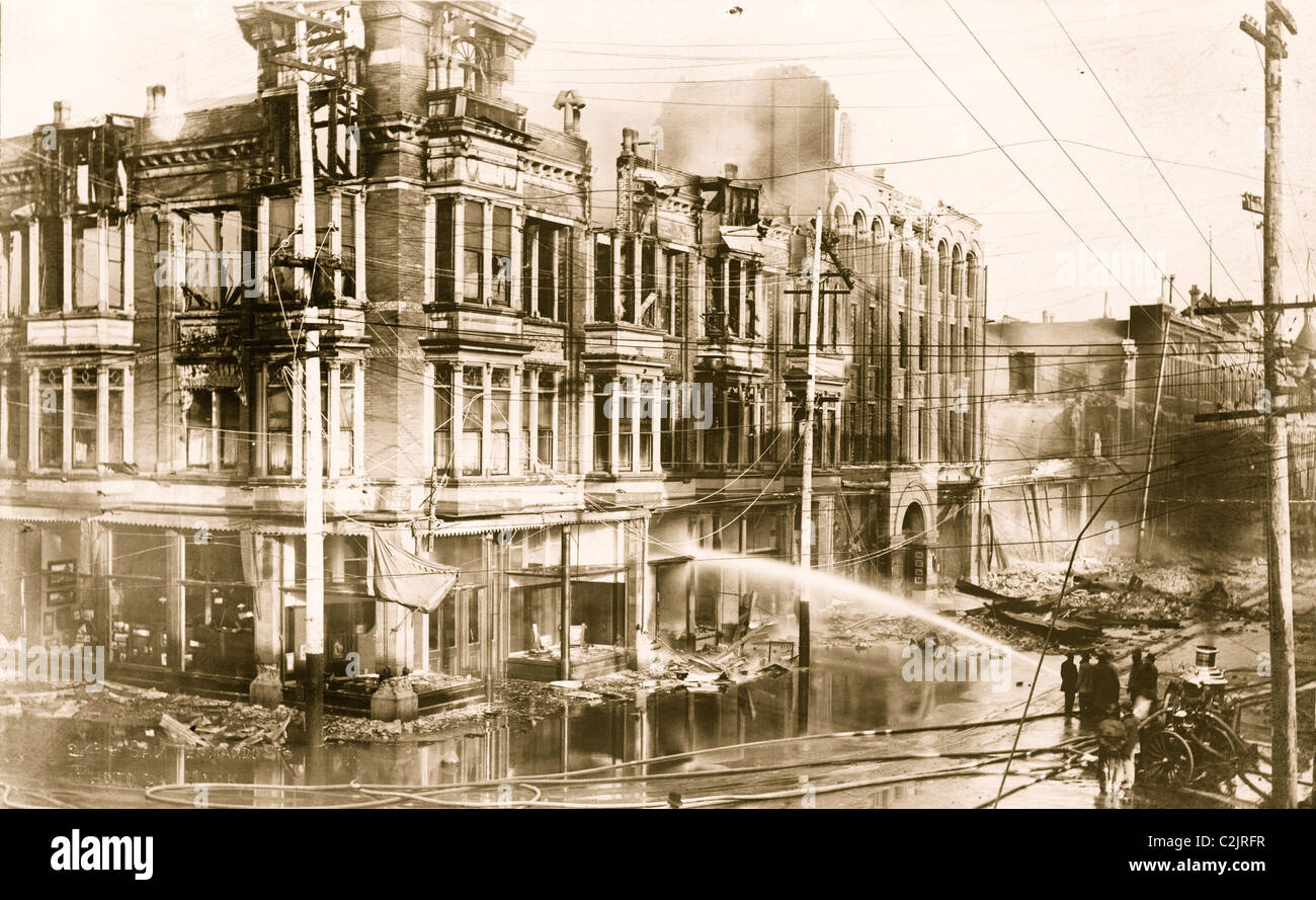 Blocco di edifici bruciati in San Francisco dopo il terremoto del 1906 con il camion dei pompieri la spruzzatura di acqua su di essi Foto Stock