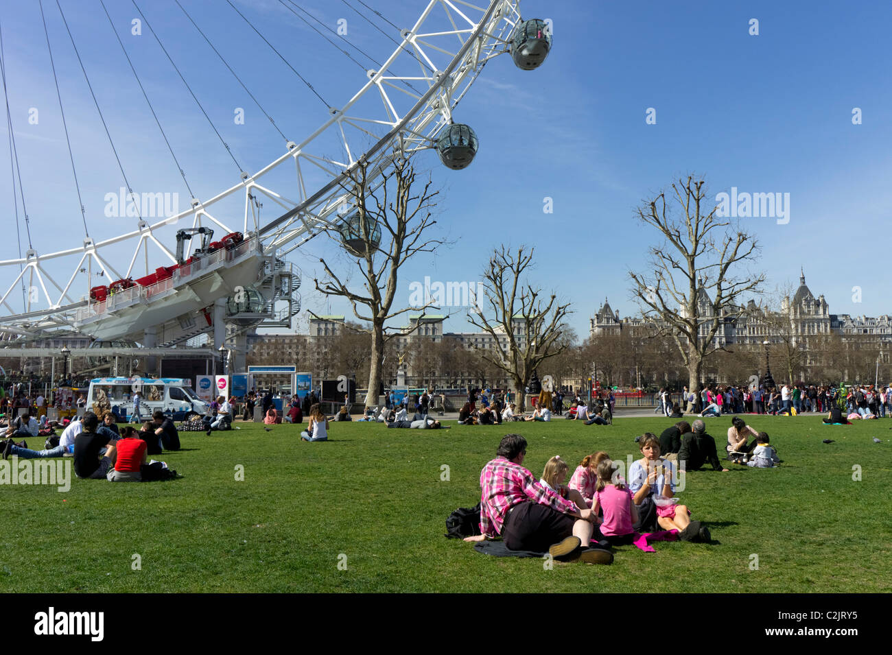 Gruppo di persone godendo il sole a Jubilee Gardens vicino al London Eye, London, England, Regno Unito Foto Stock